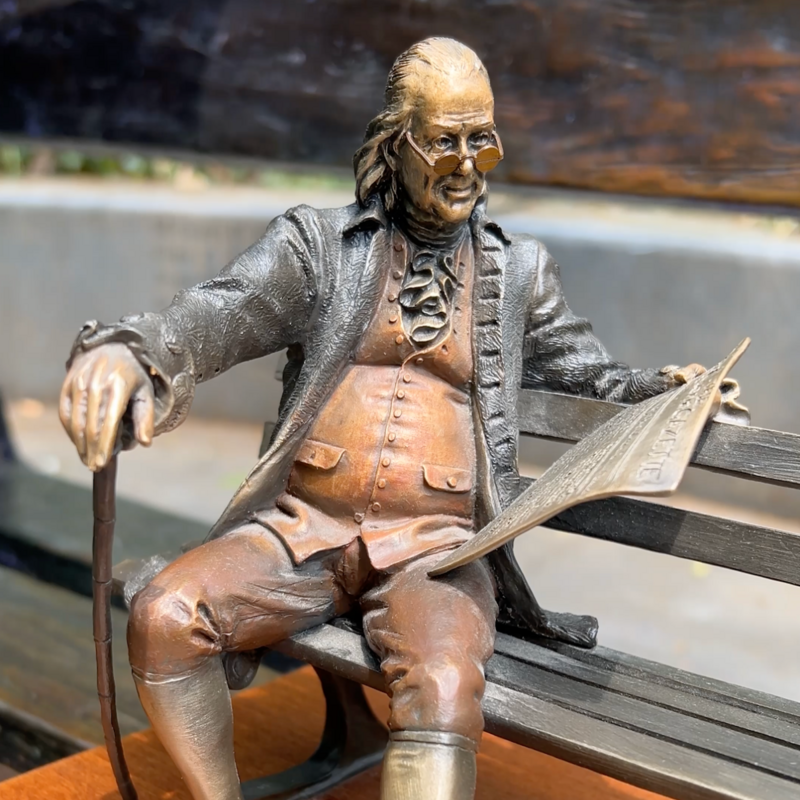 Close up of a miniature "Ben on the Bench" replica